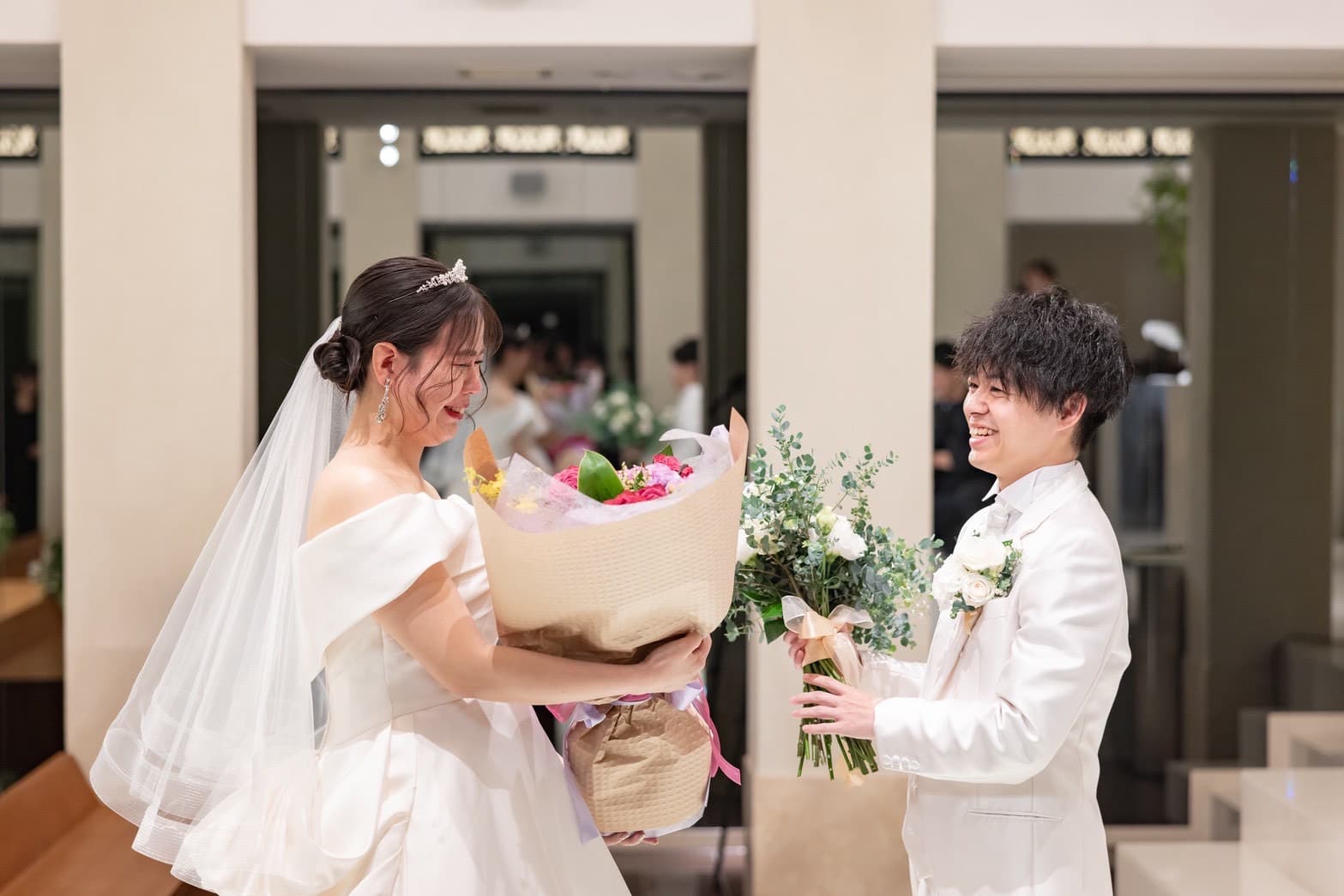 結婚式で新婦が新郎からが花束を受け取っているシーン